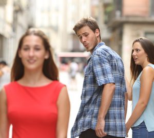man walking with his girlfriend and looking amazed at another seductive girl