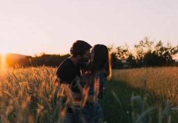 ett kärleksfullt par utbyter kyssar i ett vetefält