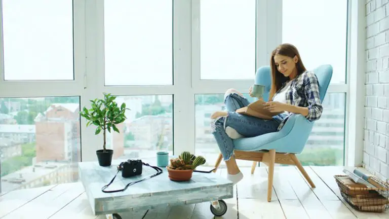 en flicka som sitter i ett soligt rum och läser en bok